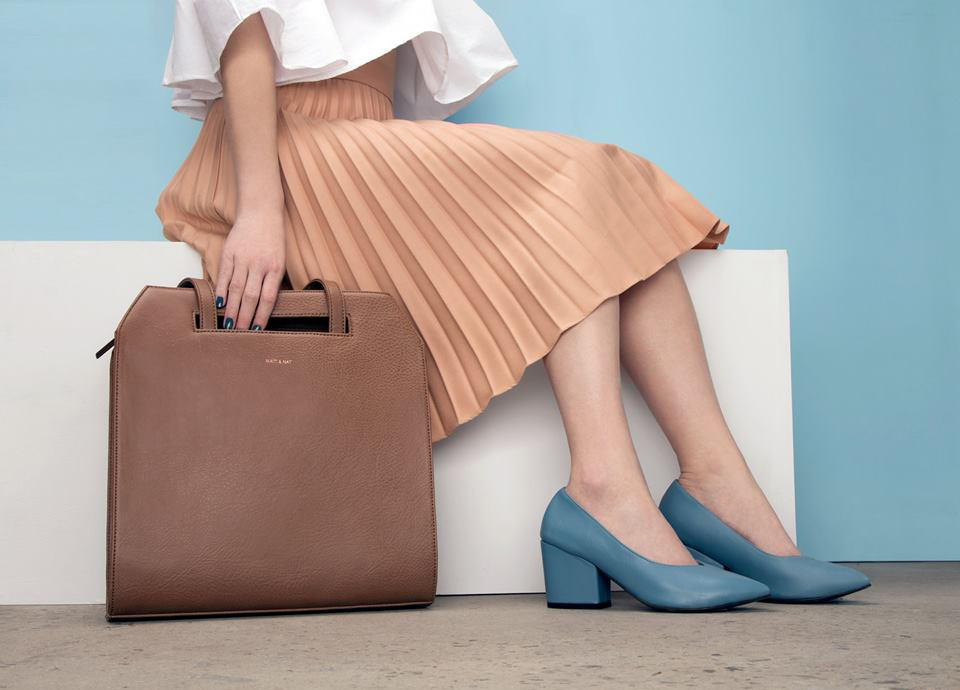 sac tenu par la main d'une femme assise sur un plot